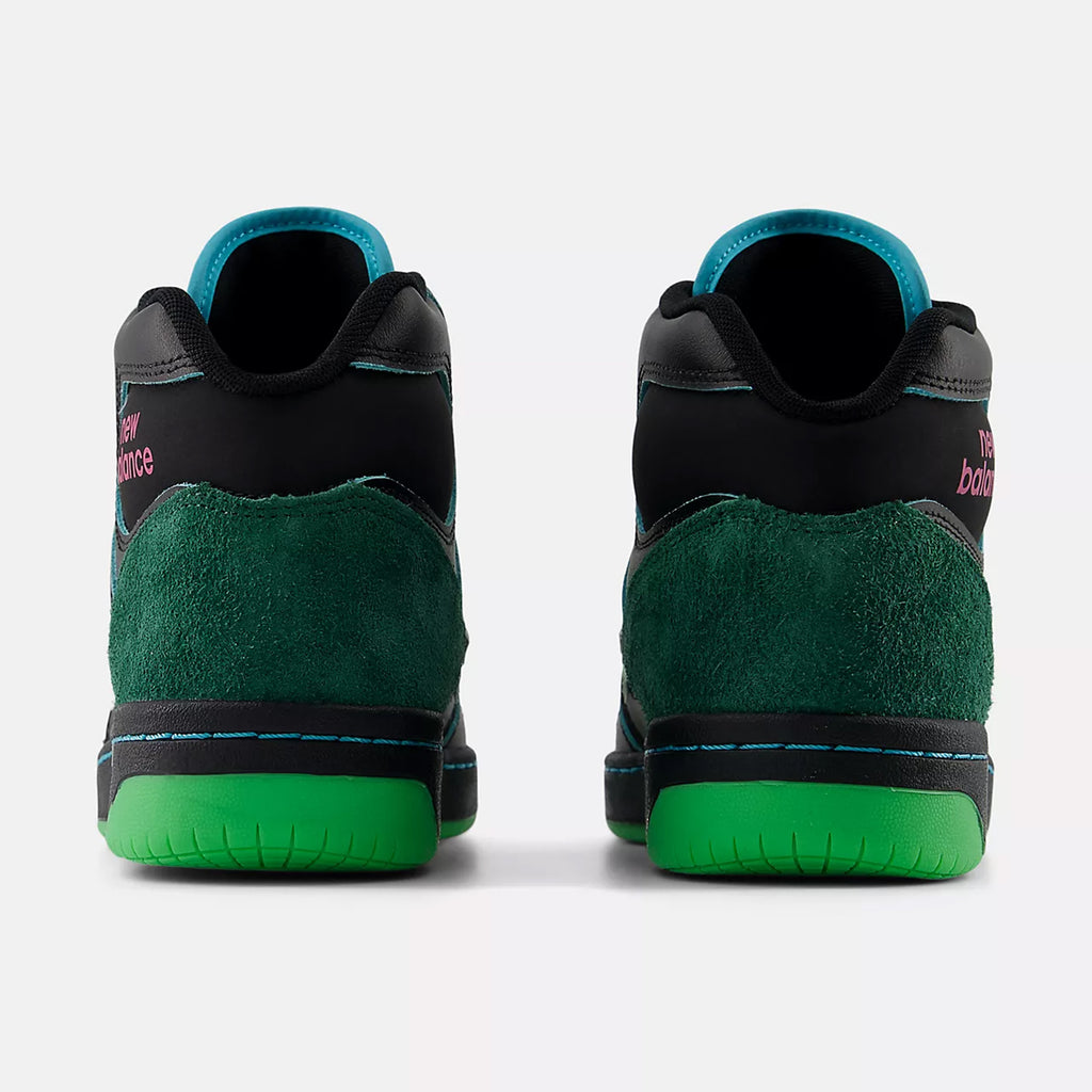 Rear view of a pair of black and green high-top sneakers with turquoise lining and bright green outsoles, featuring the "NB NUMERIC" logo in pink on the back. These NB NUMERIC X NATAS KAUPAS 480 HIGH BLACK / LIME GREEN shoes are perfect for life on and off the board.