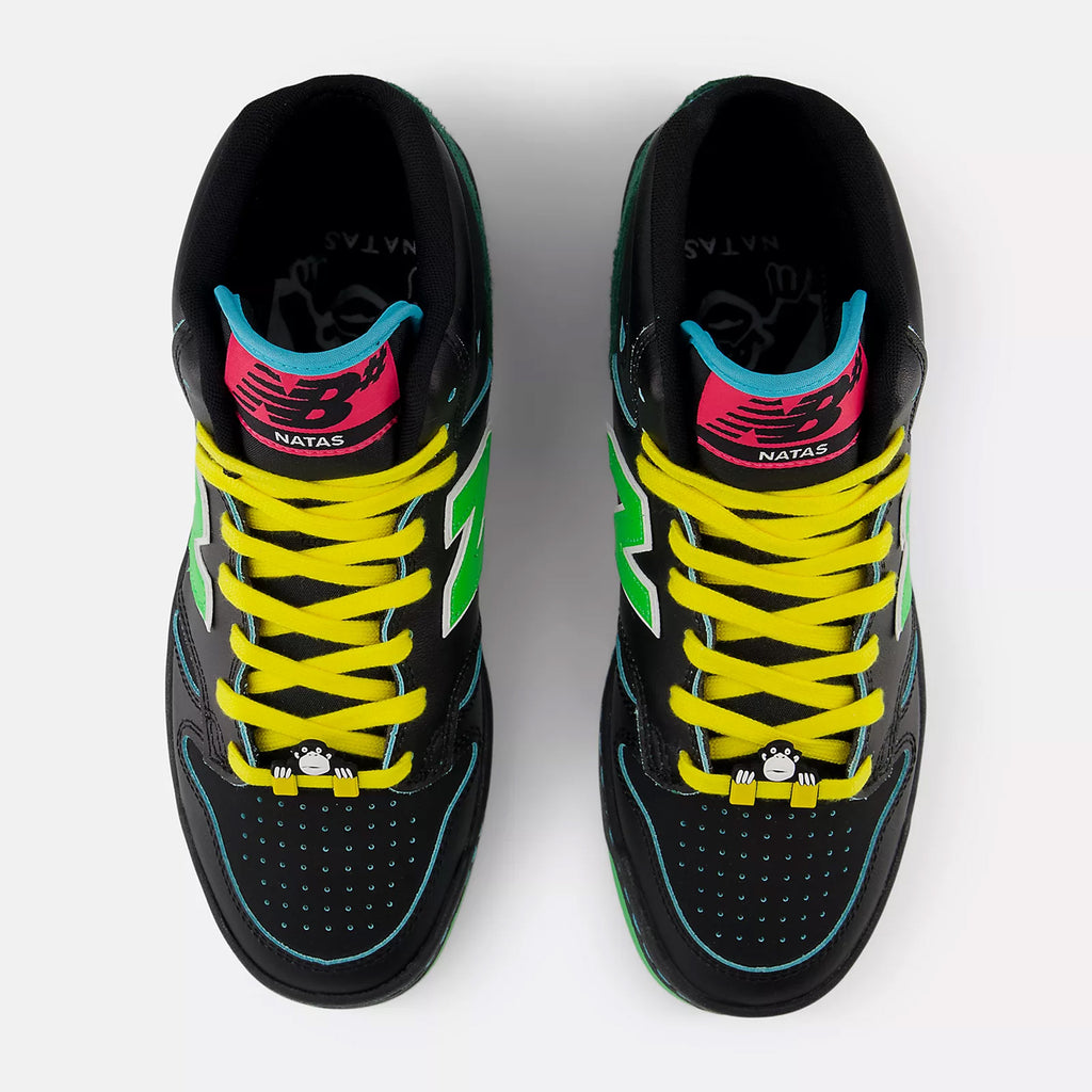 Top view of a pair of black NB NUMERIC NB NUMERIC X NATAS KAUPAS 480 HIGH BLACK / LIME GREEN skaters shoes with yellow laces, green accents, and pink detailing on the tongue, perfect for life on and off the board.