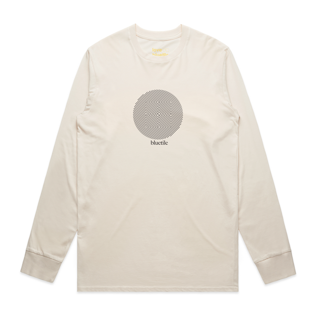 A cream colored long sleeve tee with a geometric image of squares inside of a circle and "bluetile".