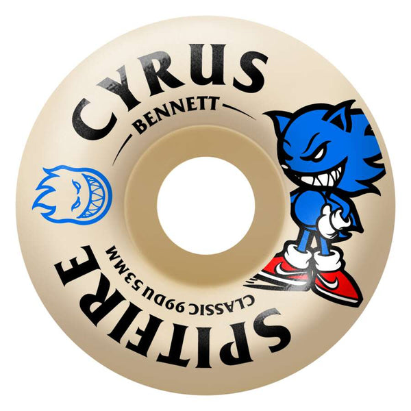 The SPITFIRE F4 CYRUS BURN SQUAD CLASSIC 99D 53MM skateboard wheel features a beige color, medium width riding surface, blue cartoon graphic with red shoes, black text, and durable SPITFIRE F4 construction.