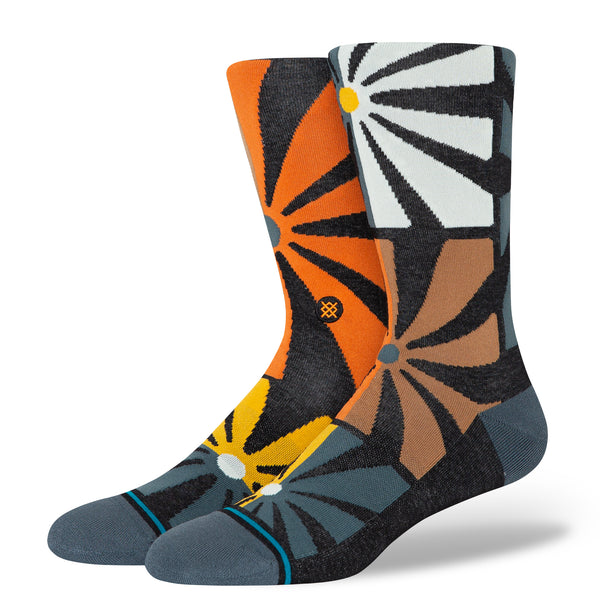 A pair of large Stance STANCE SOCKS AUBADE BLACK socks with orange and yellow designs.