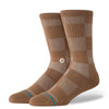 The STANCE SOCKS DOWN AND OUT BROWN LARGE are brown and beige checkered crew socks with a ribbed upper, cushioned comfort, and a small round logo near the ankle.