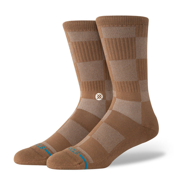The STANCE SOCKS DOWN AND OUT BROWN LARGE are brown and beige checkered crew socks with a ribbed upper, cushioned comfort, and a small round logo near the ankle.