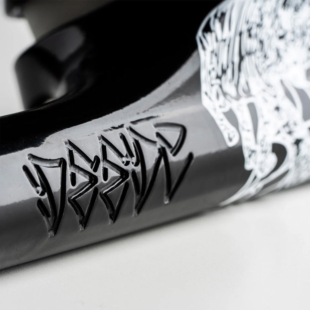 Close-up of a black object with intricate white artwork and angular, carved text. The carving has sharp, geometric lines, and the white design depicts an abstract figure. The piece is mounted on robust T6 heat-treated baseplates for enhanced durability. This is the Ace ACE AF1 55 LIMITED HOLLOW DEEDZ (SET OF TWO).