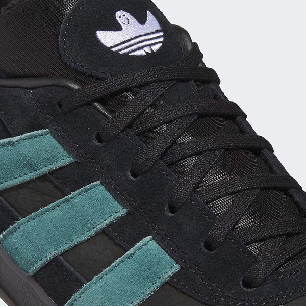 Close-up of the ADIDAS GONZ ALOHA SUPER CORE BLACK / PRELOVED TEAL sneaker showing a suede upper with teal stripes, black laces, a white Adidas tongue logo, and Adiprene cushioning for comfort.