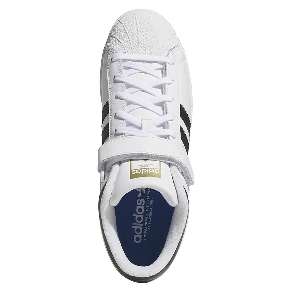 Top view of the ADIDAS PRO SHELL ADV FLAT WHITE / CORE BLACK sneaker featuring black stripes, a white Velcro strap, white laces, and a blue Adidas-logo insole—blending basketball heritage with skate innovation.