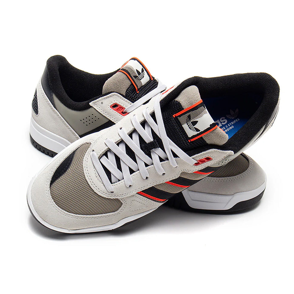 A pair of ADIDAS TEKKIRA CUP sneakers in Orbit Grey, Core Black, and Solar Red with white laces and mesh panels overlap on a white background, showcasing their classic cupsole design—ideal for skateboarding.