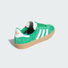 The ADIDAS GAZELLE ADV in green, cloud white, and gold metallic features premium pigskin suede with white stripes and a heel tab, plus a gum sole. Positioned to highlight the side and back, "GAZELLE" is elegantly displayed on the side.