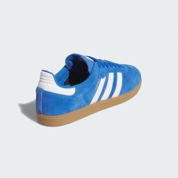The ADIDAS SAMBA ADV in Blue Bird/Cloud White/Gold Metallic features blue suede with white stripes, a tan rubber sole, and "GAZELLE" text on the side, boasting a durable cupsole for enhanced comfort.