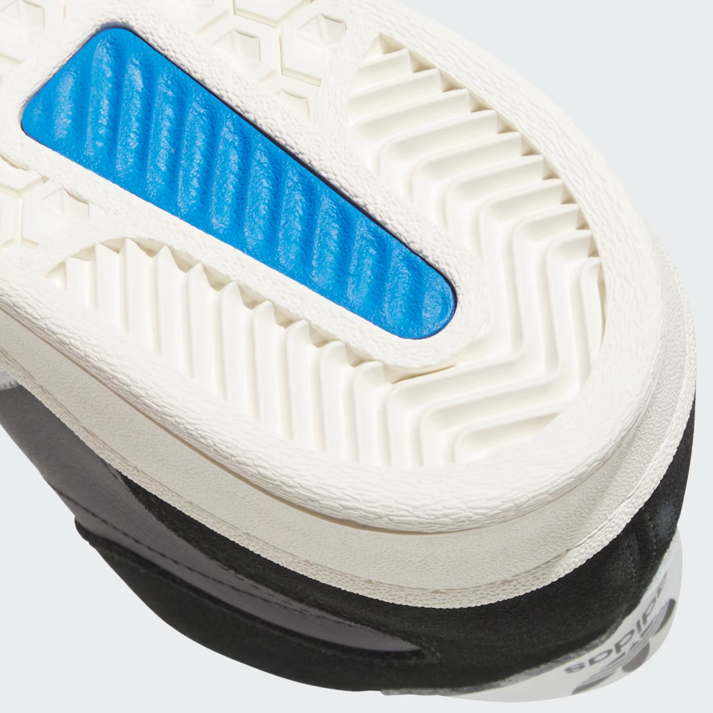 Close-up of the sole of the ADIDAS SUPERSKATE ADV in Core Black/Crystal White/Off White, showing its textured white tread, blue insert, and durable leather—ideal for skateboarding.