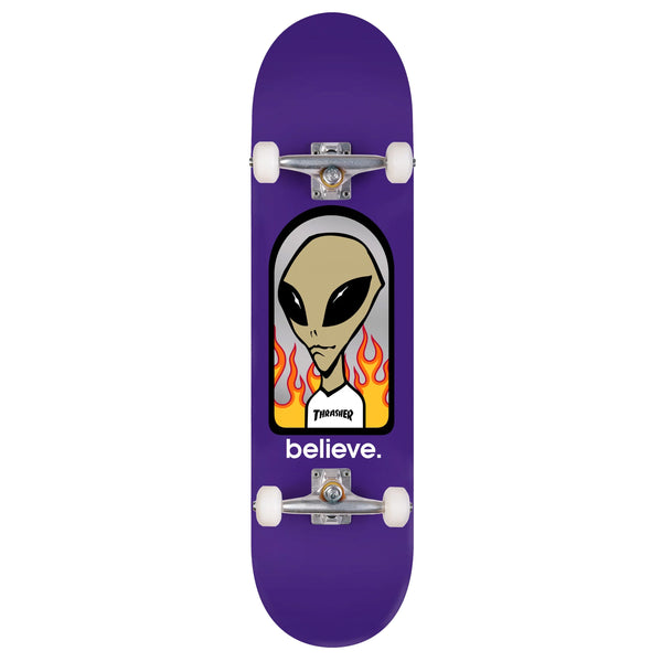 A purple ALIEN WORKSHOP X TRASHER BELIEVE COMPLETE skateboard with a picture of an alien on it.