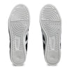 The image shows the soles of a pair of ASICS AARON PRO BLACK / WHITE shoes, displaying a circular tread pattern.