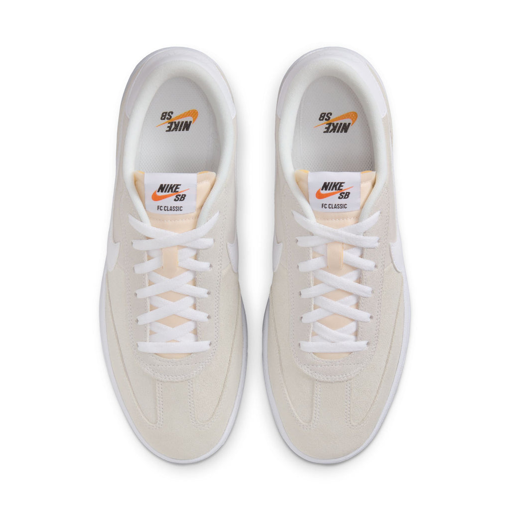 A top-down perspective of a pair of NIKE SB FC CLASSIC sneakers in Summit White, showcasing the "Nike SB" branding on the tongue. Ideal for skateboarding, these sneakers are fully laced and set against a simple background.