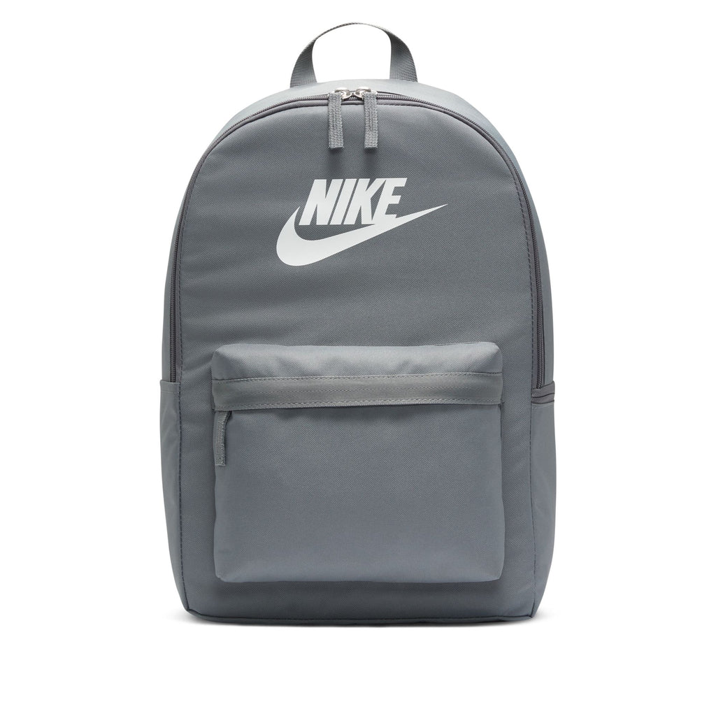 The NIKE HERITAGE BACKPACK in Smoke Grey/White, made from recycled polyester, features a white logo, front zippered pocket, top handle, and laptop sleeve.