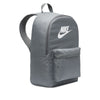 The NIKE HERITAGE BACKPACK in Smoke Grey/White is made from recycled polyester, featuring a front pocket, iconic logo, laptop sleeve, top handle, and adjustable padded shoulder straps.