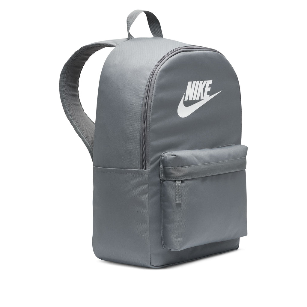 The NIKE HERITAGE BACKPACK in Smoke Grey/White is made from recycled polyester, featuring a front pocket, iconic logo, laptop sleeve, top handle, and adjustable padded shoulder straps.