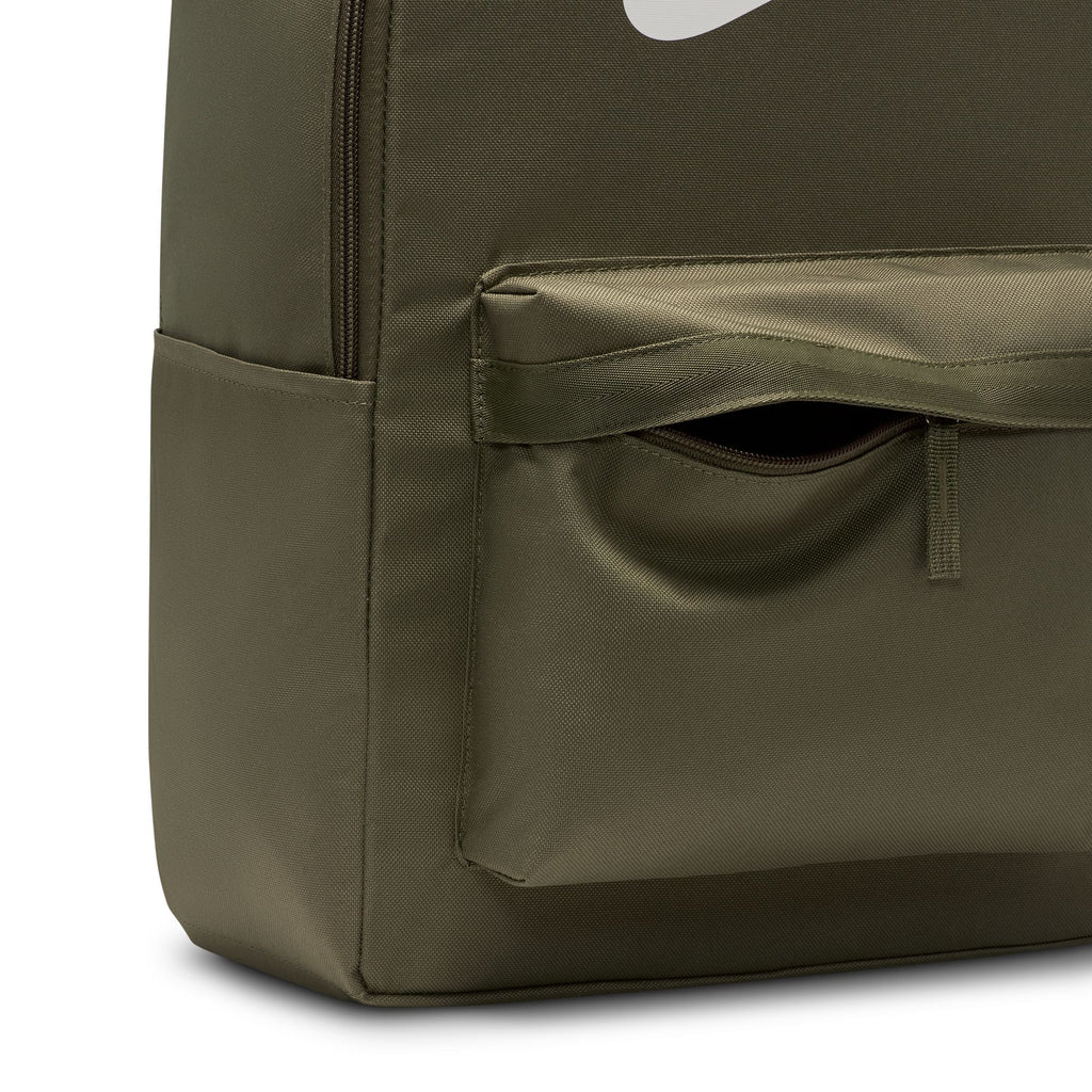 Close-up of the nike NIKE HERITAGE BACKPACK MEDIUM OLIVE, made from recycled polyester with a zippered front pocket, side pocket, partial white swoosh logo, and a convenient internal laptop sleeve.