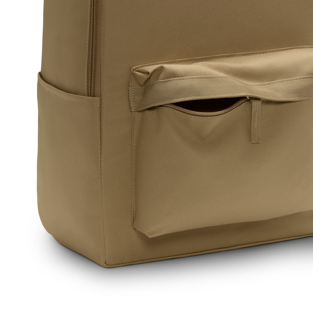 Close-up of a Nike Heritage Backpack in Parachute Beige/Summit White, featuring a front pocket with a horizontal flap, an open side pocket, and a 15" laptop sleeve. Made from smooth, sturdy recycled polyester for durability.