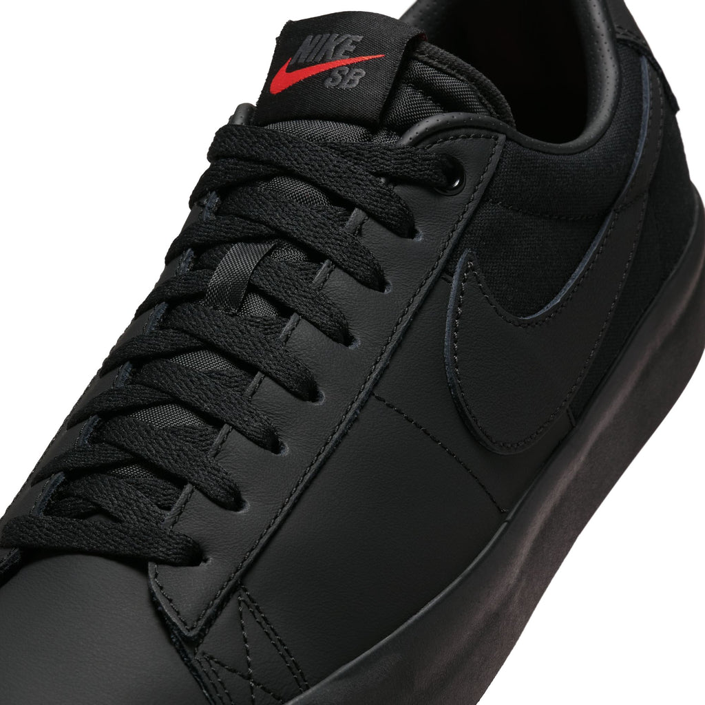 Close-up of the NIKE SB BLAZER LOW PRO GT in an all-black design, featuring a red Nike logo on the tongue, ideal for skateboarding in Columbia SC.