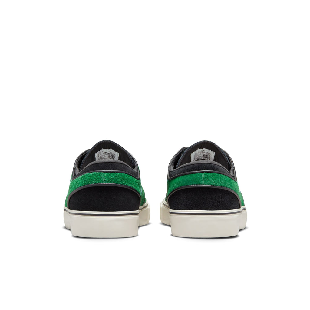 A pair of black and green NIKE SB ZOOM JANOSKI OG+ GORGE GREEN / ACTION GREEN sneakers.
