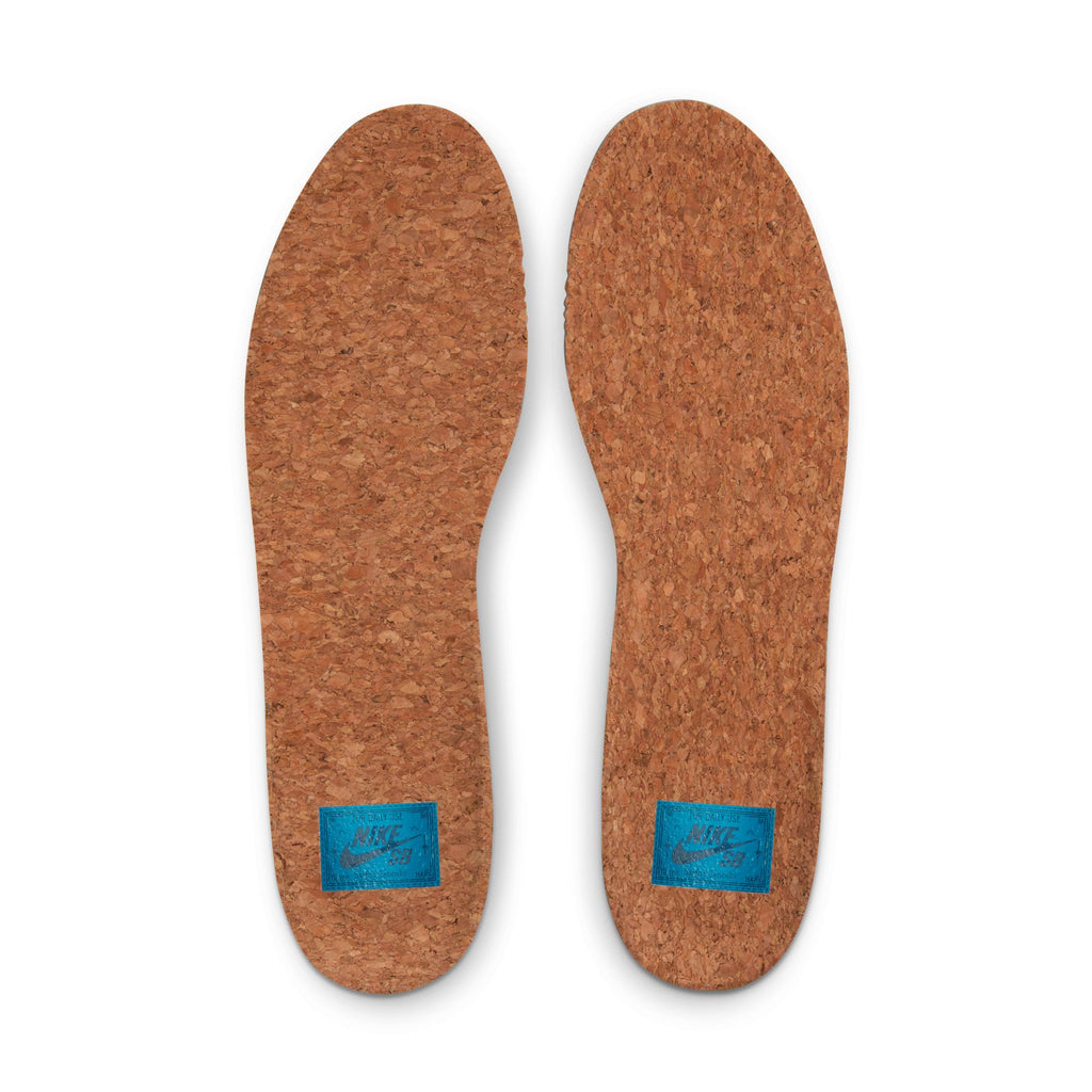 A photo of just the cork insoles with a blue nike logo on each of them.