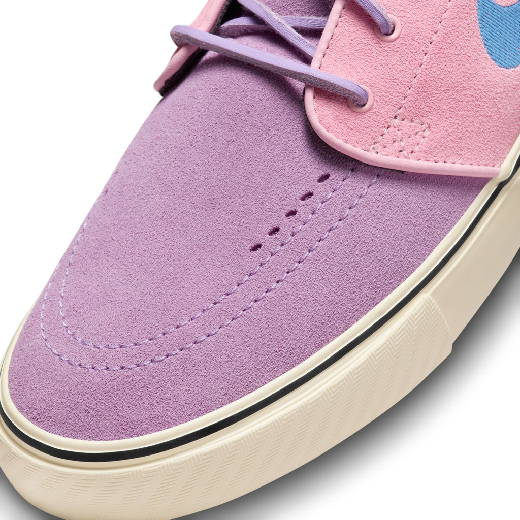 The purple suede toe cap of the shoe with lilac stitching and the classic white sole.