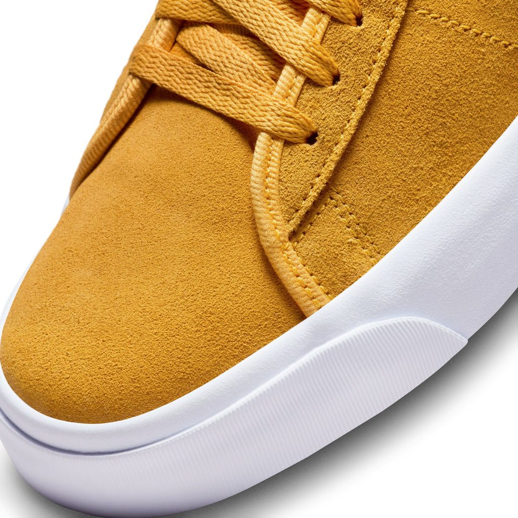 A pair of yellow Nike SB Blazer Mid Pro GT University Gold / Game Royal sneakers with white soles, perfect for skateboard enthusiasts like Grant Taylor.