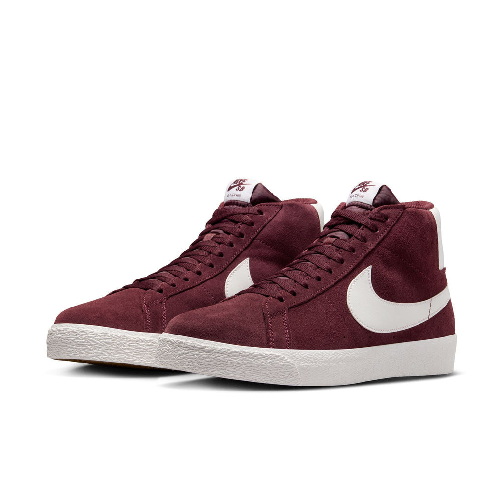 A pair of nike NIKE SB BLAZER MID BURGUNDY CRUSH / SUMMIT WHITE high-top sneakers with white swooshes, white soles, and Zoom Air cushioning perfect for any skateboarder.