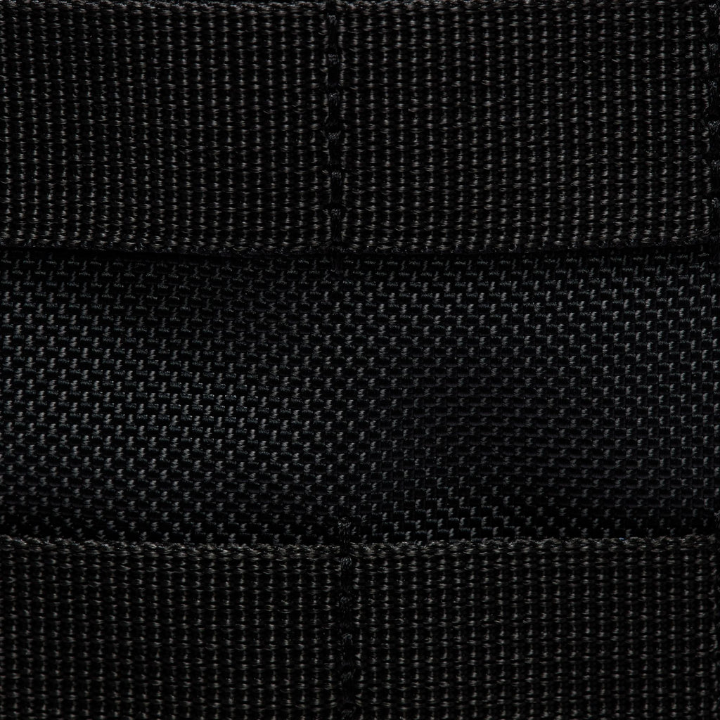 Close-up of black nylon webbing in a grid pattern on the NIKE RPM TOTE (26L) BLACK by nike, highlighting stitching and texture on its recycled polyester body.