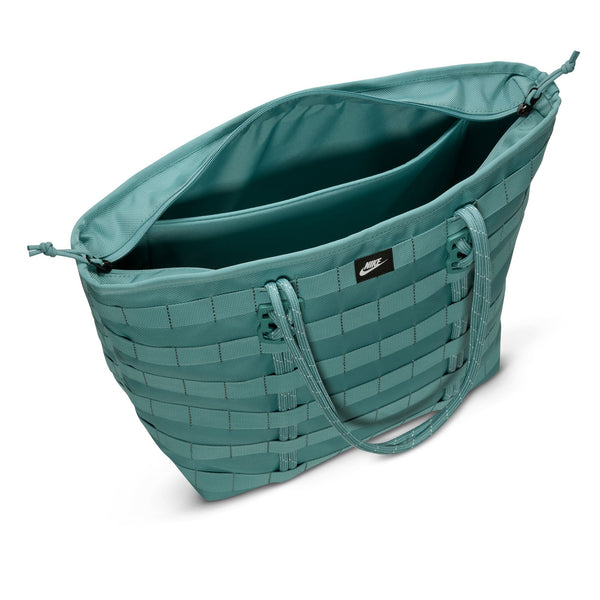 The NIKE RPM TOTE (26L) in denim turquoise/black/summit white features double handles, an open top, a roomy interior for essentials or a laptop, and a small front nike logo.