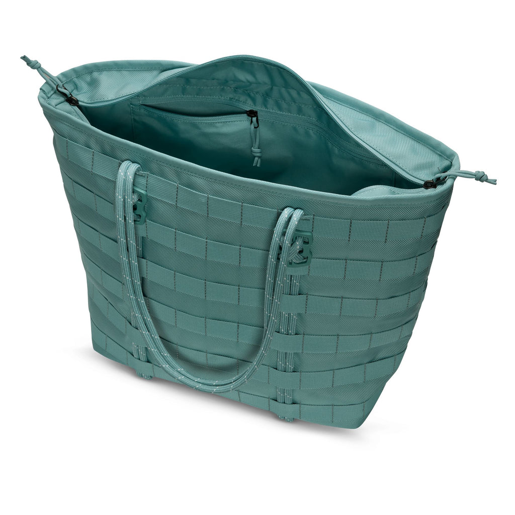 The NIKE RPM TOTE (26L) in Denim Turquoise/Black/Summit White by Nike features two handles, an open main compartment, and an interior zip pocket—ideal for carrying your laptop and daily essentials in style.