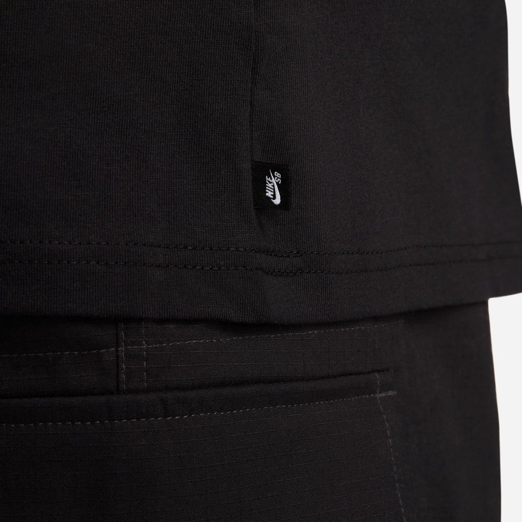 A small nike sb logo tag sewn into the side of a black tshirt.