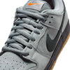 Close-up of the NIKE SB DUNK LOW PRO in Cool Grey/Black, featuring gray laces, a black Nike swoosh, gum sole, and an orange Nike SB logo on the tongue.