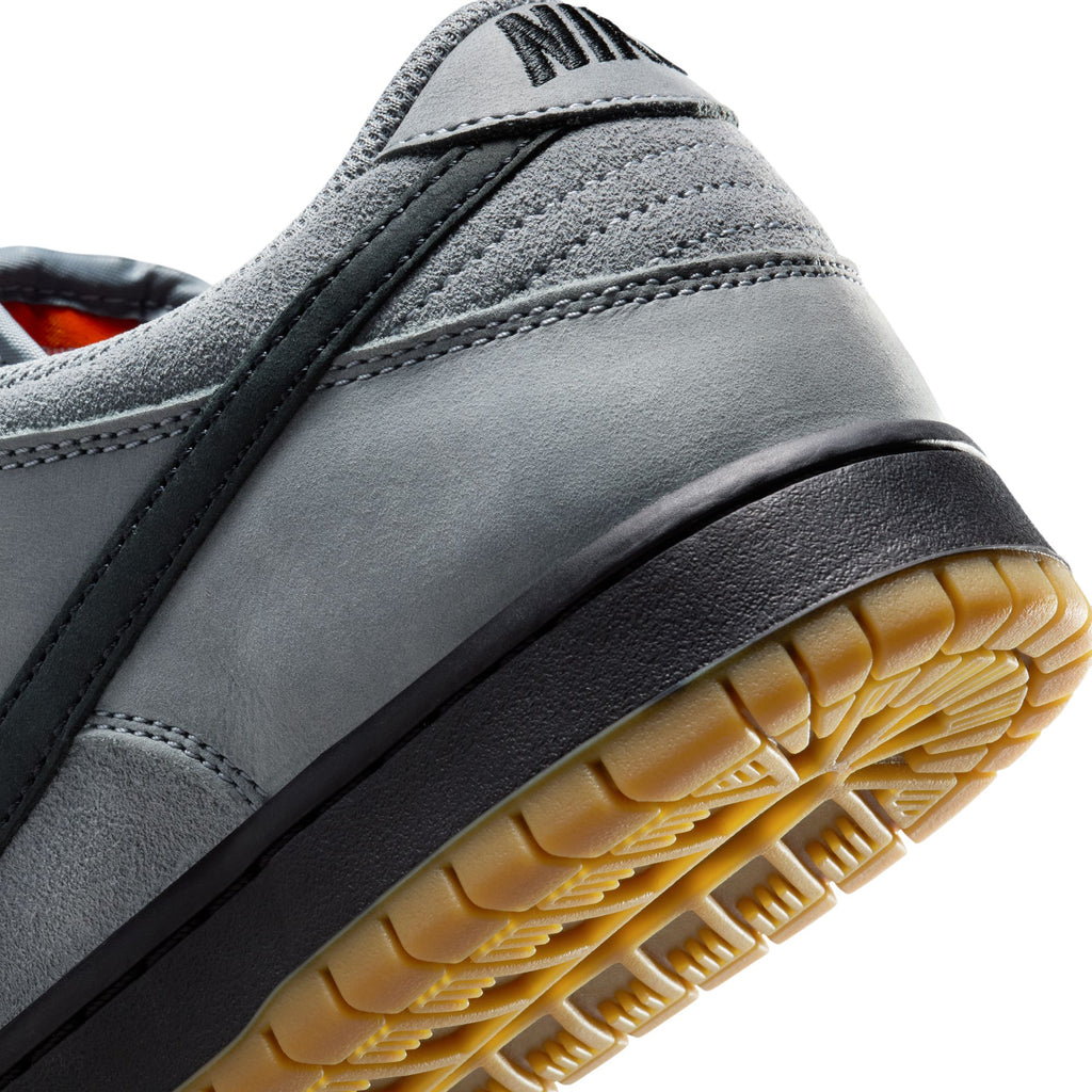 Close-up of the heel and sole of the nike SB DUNK LOW PRO COOL GREY / BLACK-COOL GREY-DARK GREY, featuring a black stripe and yellow outsole that highlights its skateboarding shoe design.