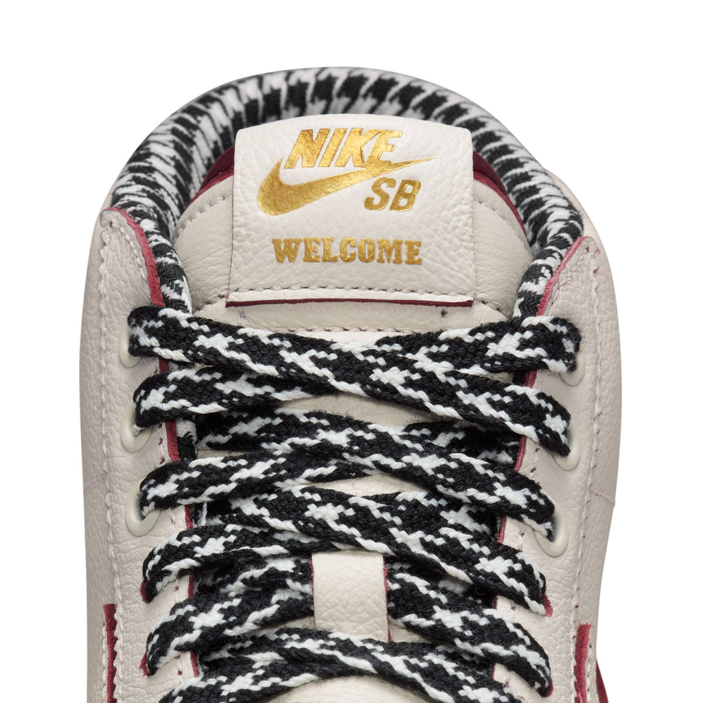 The timeless design of the Nike SB x Welcome Madrid Blazer Mid Sail/Dark Beetroot-White is showcased in white and gold.