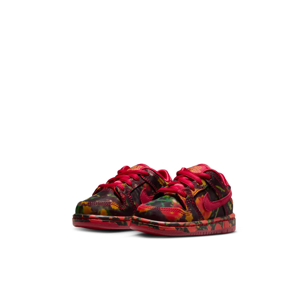 The NIKE SB DUNK LOW 👠💚 TODDLER shoes feature a vibrant red, green, and yellow camo design with bright red laces and a clean white background, reminiscent of the bold style found in Nike's iconic designs.
