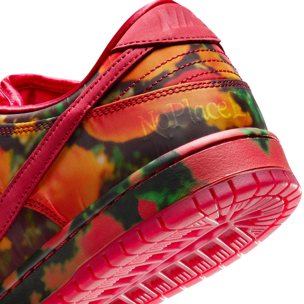 Close-up of the colorful NIKE SB DUNK LOW 🧙‍♂️ by Nike, featuring a red sole and trim. The side displays a camouflage pattern with "No Place Like Home." A plush suede upper enhances its vibrant design, while the foam midsole provides ultimate comfort and support.