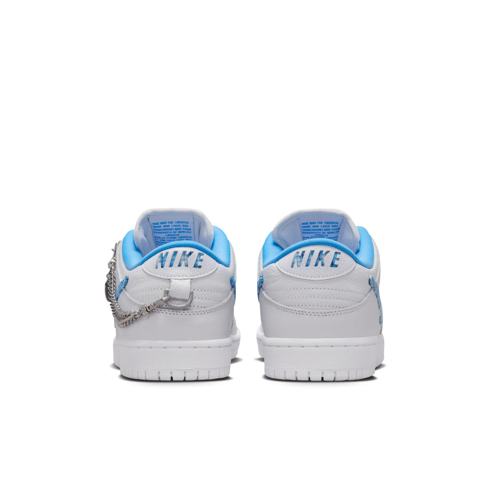 Rear view of a pair of NIKE SB X NICOLE HAUSE DUNK LOW PRO sneakers in white with blue accents and black "NIKE" text on the heel, featuring a chain on the left shoe. These stylish classics from Nike offer comfort in every step.