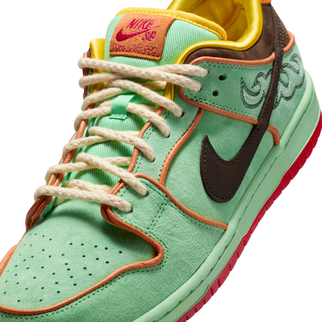 Close-up of the NIKE SB RODEO DUNK LOW TOURMALINE/BAROQUE BROWN-MONARCH by nike, showcasing mint green suede, orange trim, brown accents, rope laces, and a red outsole—unique design inspired by Southwest heritage.