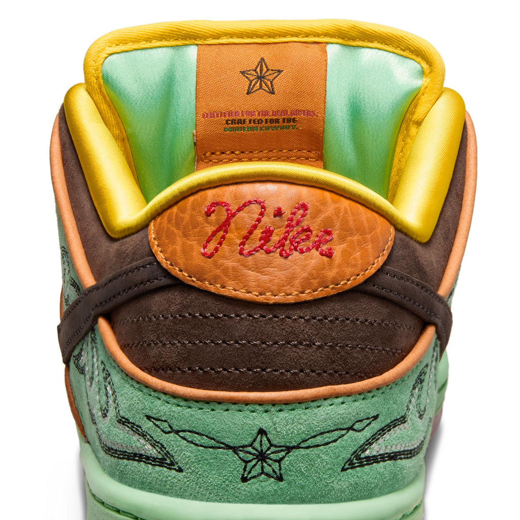 Close-up of the heel and tongue of the nike NIKE SB RODEO DUNK LOW TOURMALINE/BAROQUE BROWN-MONARCH, featuring vibrant orange, green, brown, and yellow accents with detailed embroidery celebrating Southwest heritage.