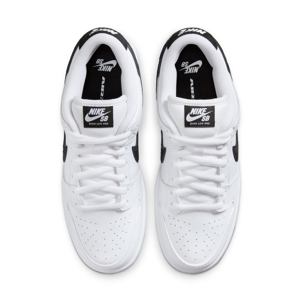 Top view of Nike SB Dunk Low Pro in white/black featuring a suede upper and black detailing with logos on the tongue and insole, finished with a durable rubber outsole for grip.