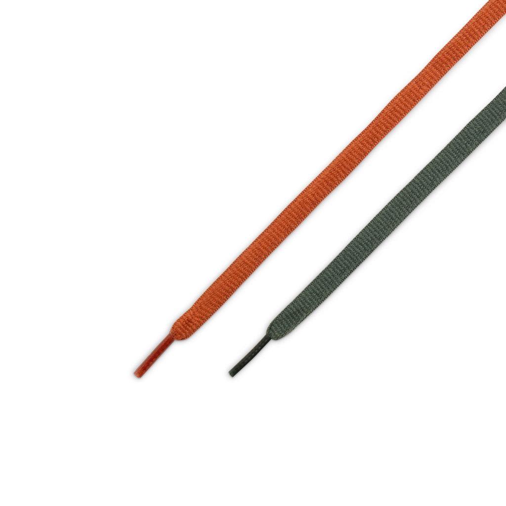 Close-up of one University Red shoelace and one gray shoelace laid flat on a white background, reminiscent of the iconic nike NIKE SB DUNK LOW PRO BURNT SUNRISE / VINTAGE GREEN style.