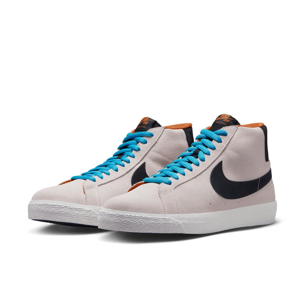 Introducing the NIKE SB ZOOM BLAZER MID in Electric Phantom, Black-Monarch, and Summit White. This high-top skateboarding shoe features a white body with a black Nike swoosh, brown accents, blue shoelaces, and Zoom Air cushioning for extra comfort.