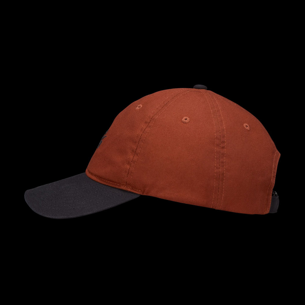The NIKE SB CLUB HAT CINNAMON by Nike features a cinnamon-colored crown and black brim in durable cotton twill, shown in a side profile against a black background. An adjustable back strap provides a comfortable fit.