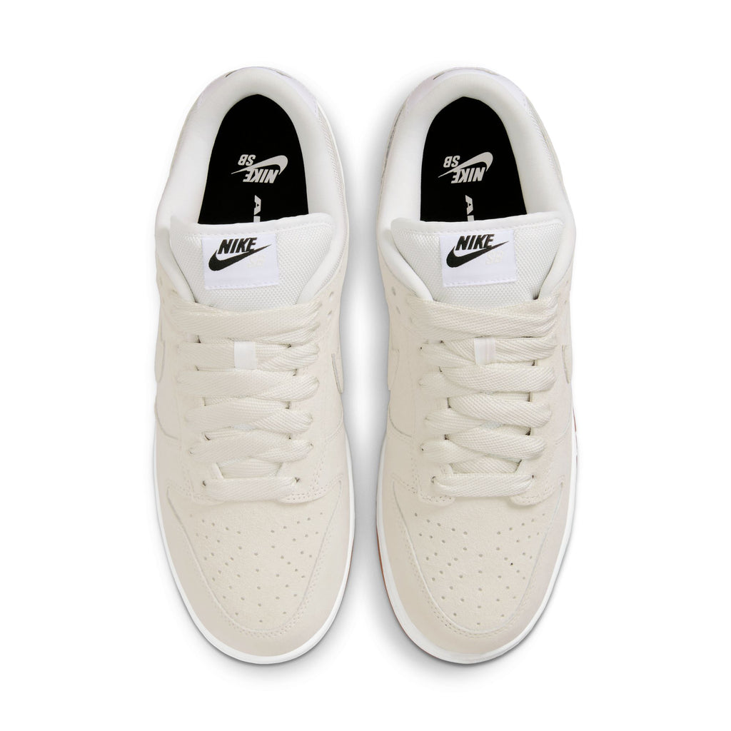 Top view of nike SB Dunk Low Pro B Pale Ivory/Summit White shoes, featuring perforated toe boxes, white laces, and black Nike branding on the tongue and insole.