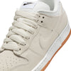 Close-up of the NIKE SB DUNK LOW PRO B in Pale Ivory/Summit White by Nike, featuring white laces, a white midsole, gum rubber outsole, and visible Nike logos on the tongue and side.