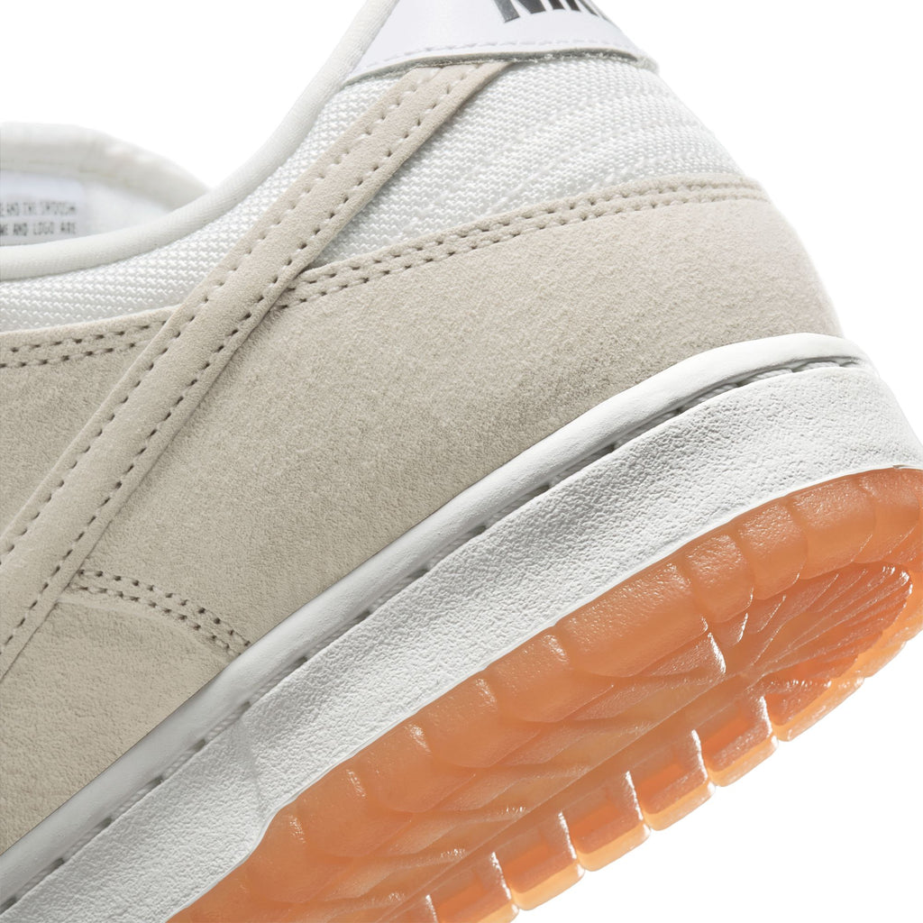Close-up of the heel and sole of a nike SB Dunk Low Pro B in Pale Ivory and Summit White, featuring an orange translucent outsole.