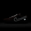 The nike SB x Limo Dunk Low Pro in Dark Pony/Black-Silver-White features football-textured black leather, a reflective white Swoosh, and a small reflective logo near the heel, shown against a dark background.