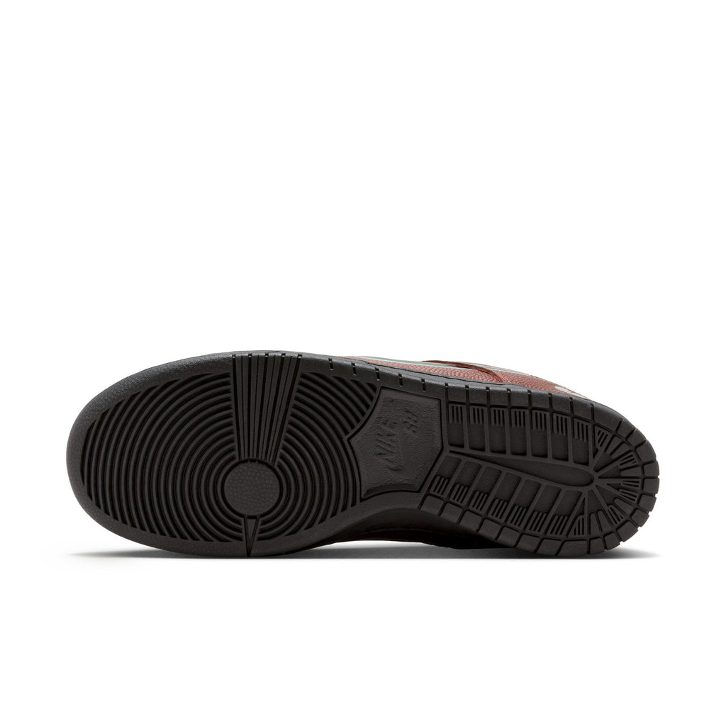 The image shows the bottom view of a black rubber sole from the NIKE SB X LIMO DUNK LOW PRO DARK PONY / BLACK-SILVER-WHITE sneaker, featuring varied tread patterns, a visible Nike SB logo, and football-textured leather accents for style.