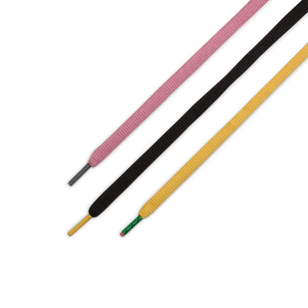 Three flat shoelaces—pink with a gray tip, black with a yellow tip, and yellow with a green tip—are arranged diagonally on white, inspired by the bold colorways of the NIKE SB X CSEF DUNK LOW SUMMIT WHITE / BLACK-WHITE-IRON GREY.